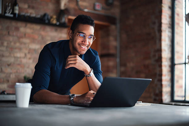 IT technician working on a laptop in a home environment